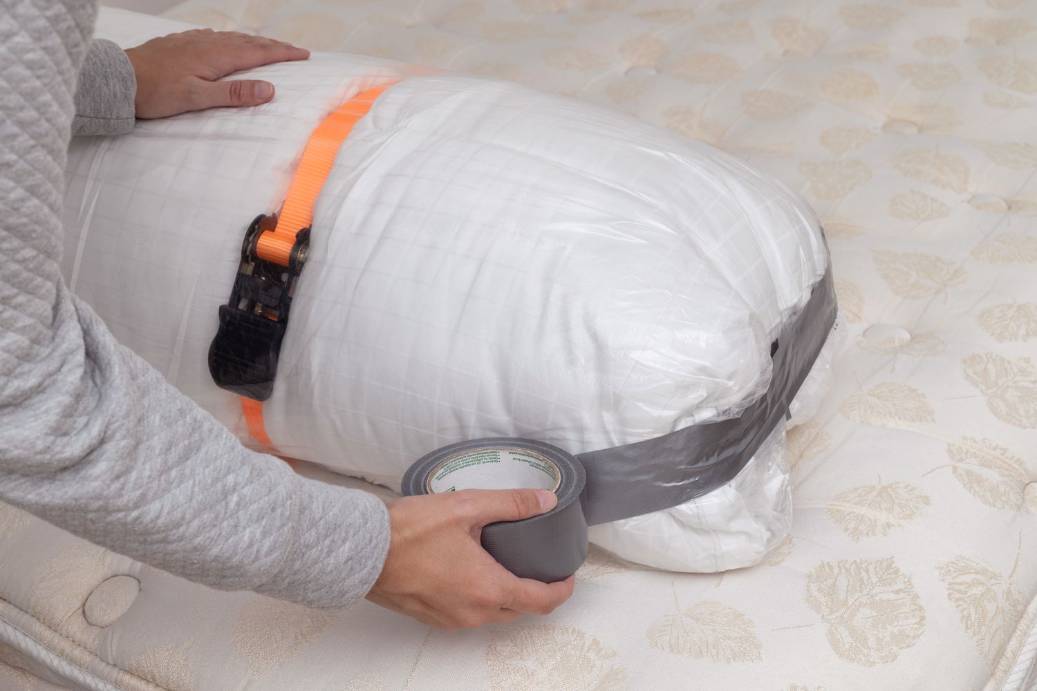 Mattress topper wrapped in vacuum sealing bag and sealed with duct tape