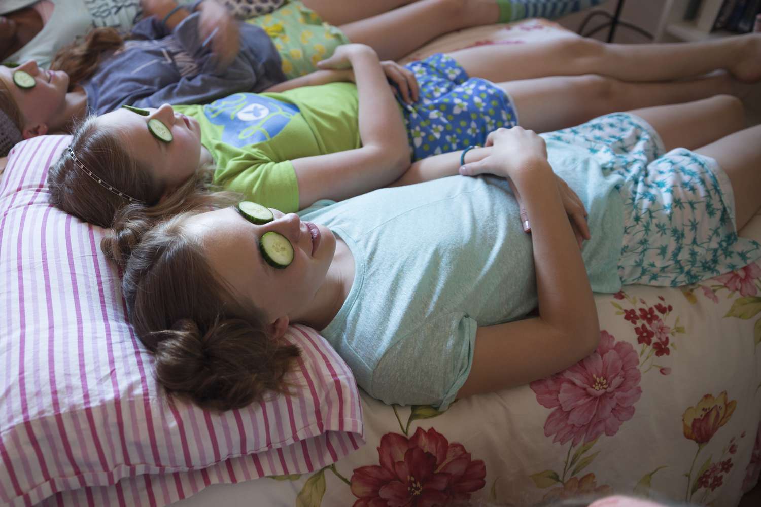 Mädchen entspannen sich mit Gurken auf den Augen bei der Schlummerparty