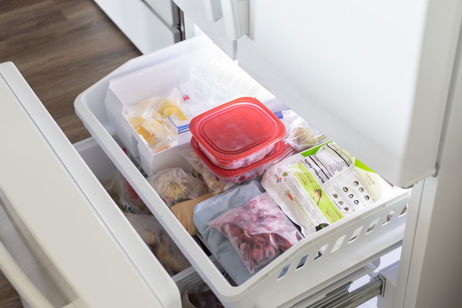 Freezer cheio de alimentos e recipientes congelados para reduzir a conta de luz