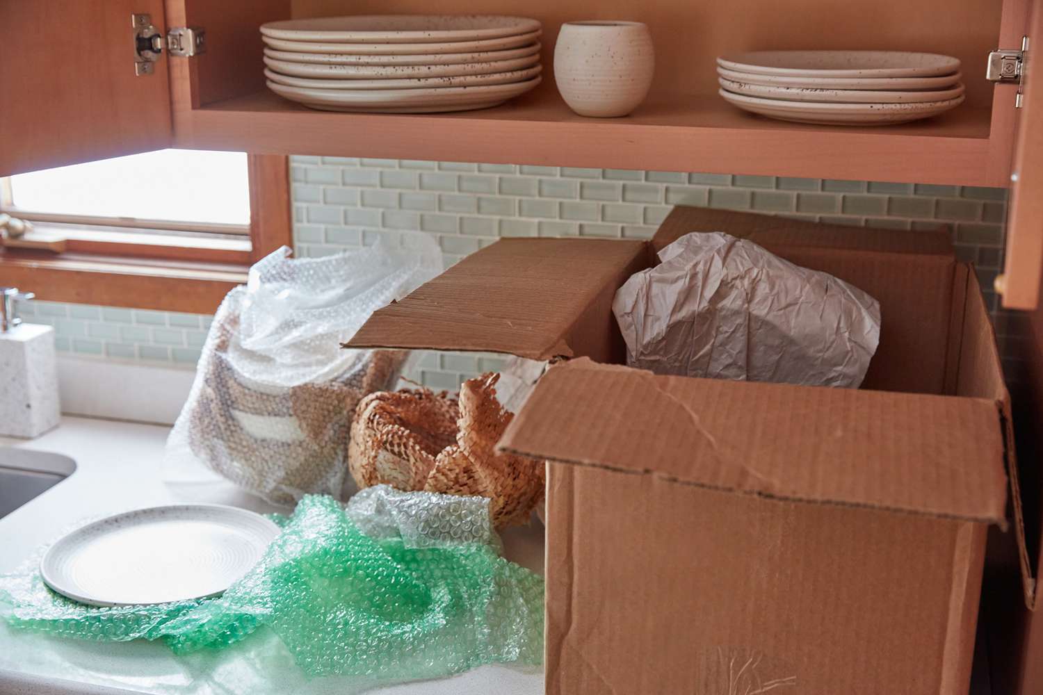 Armarios de cocina limpios de vajilla y colocados en una caja de cartón