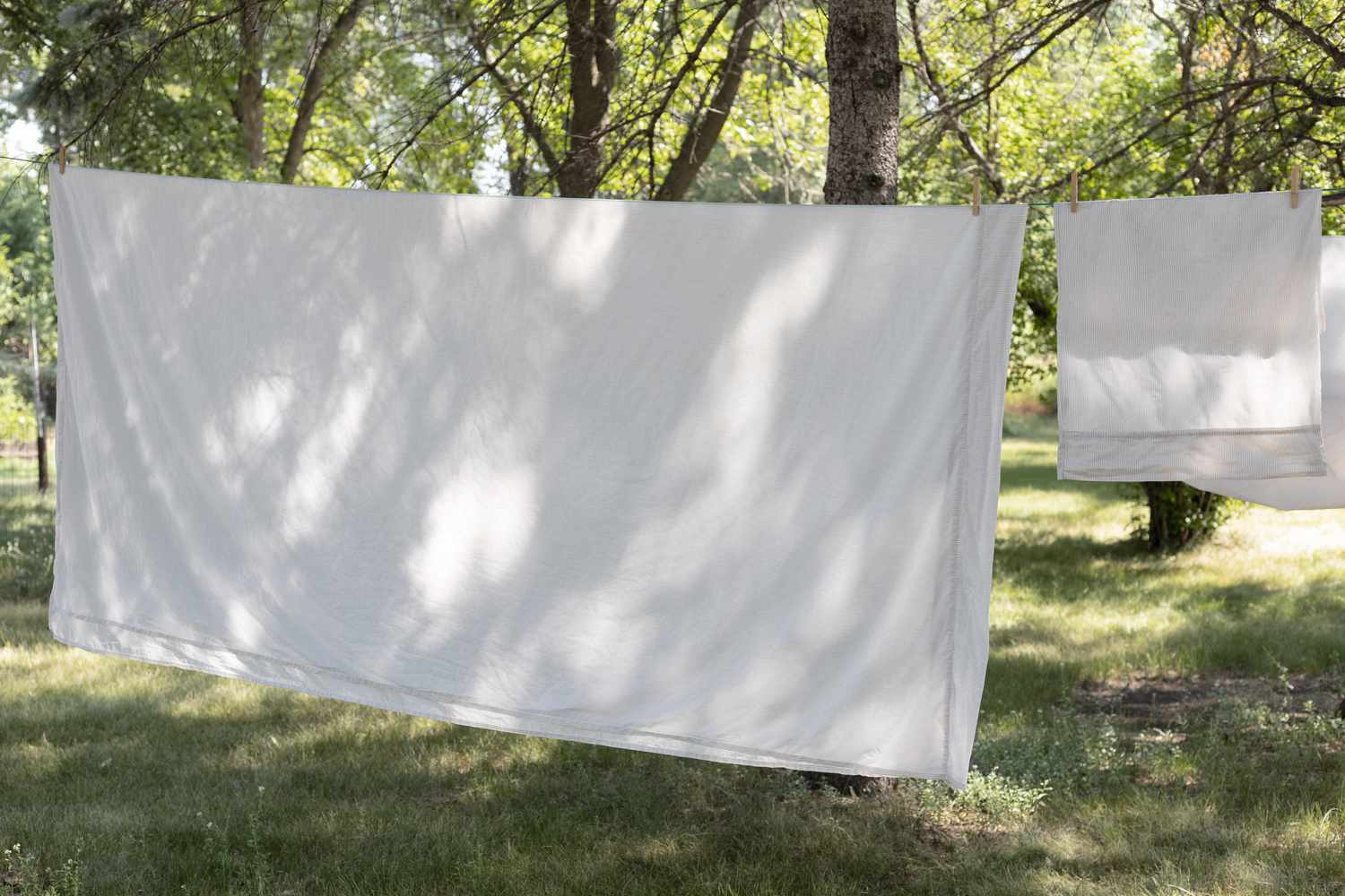 Lençóis e toalhas brancos sendo secados em linha para reduzir a conta de luz