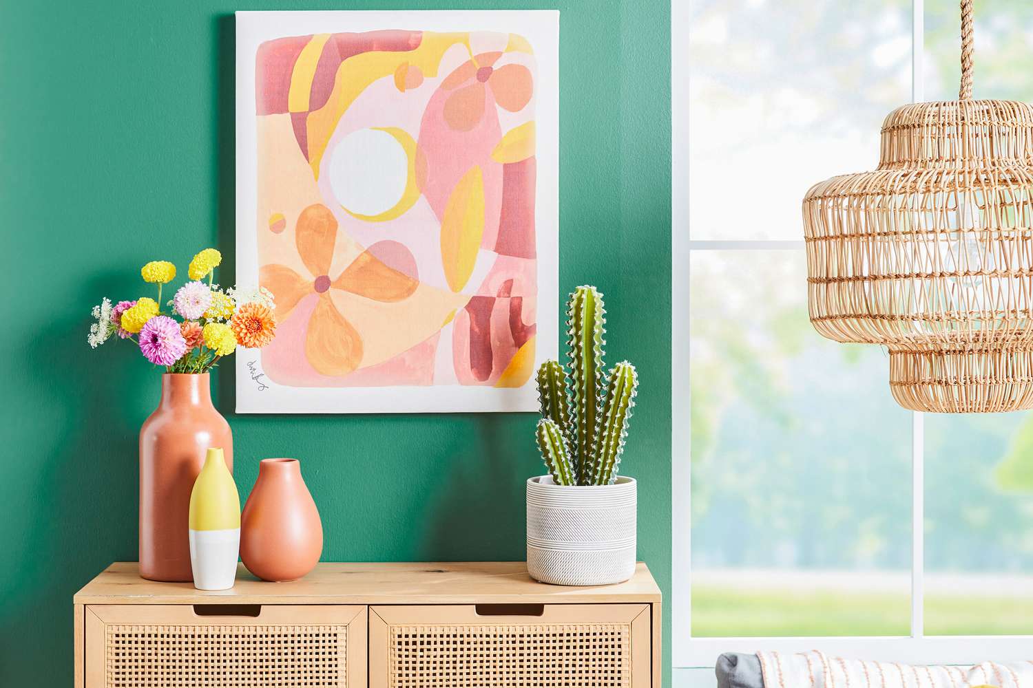 Fleurs et cactus sur une table dans une pièce peinte en vert