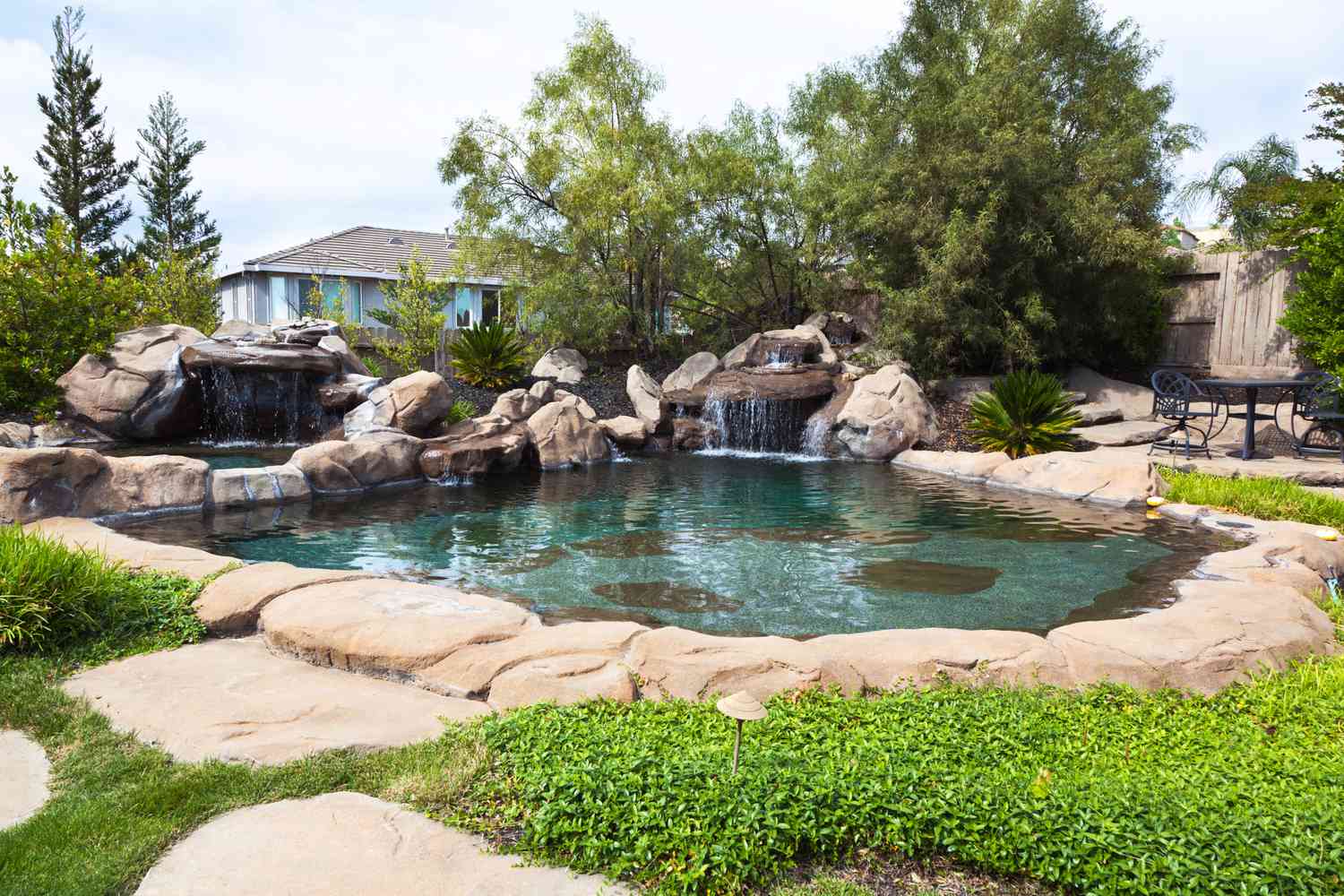 Uma piscina natural cercada por pedras e uma cachoeira de pedras.