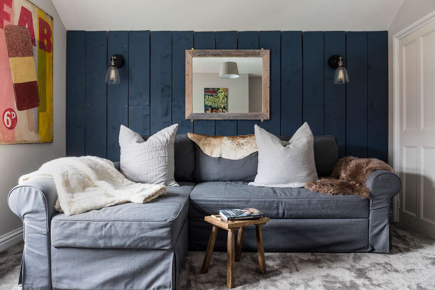 petit salon avec tapis gris et mur d'accent bleu