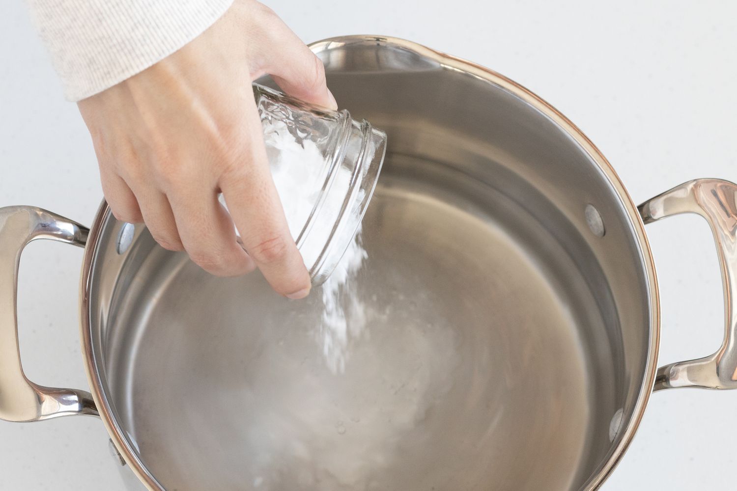 adding baking soda to a pot of water