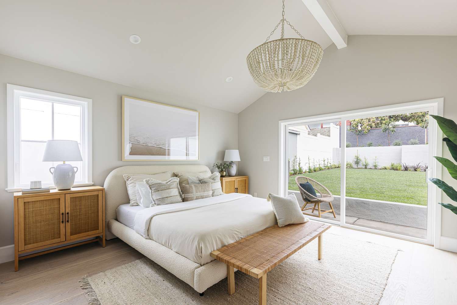 Dormitorio tranquilo con paredes pintadas de gris claro y una gran ventana que da al patio trasero