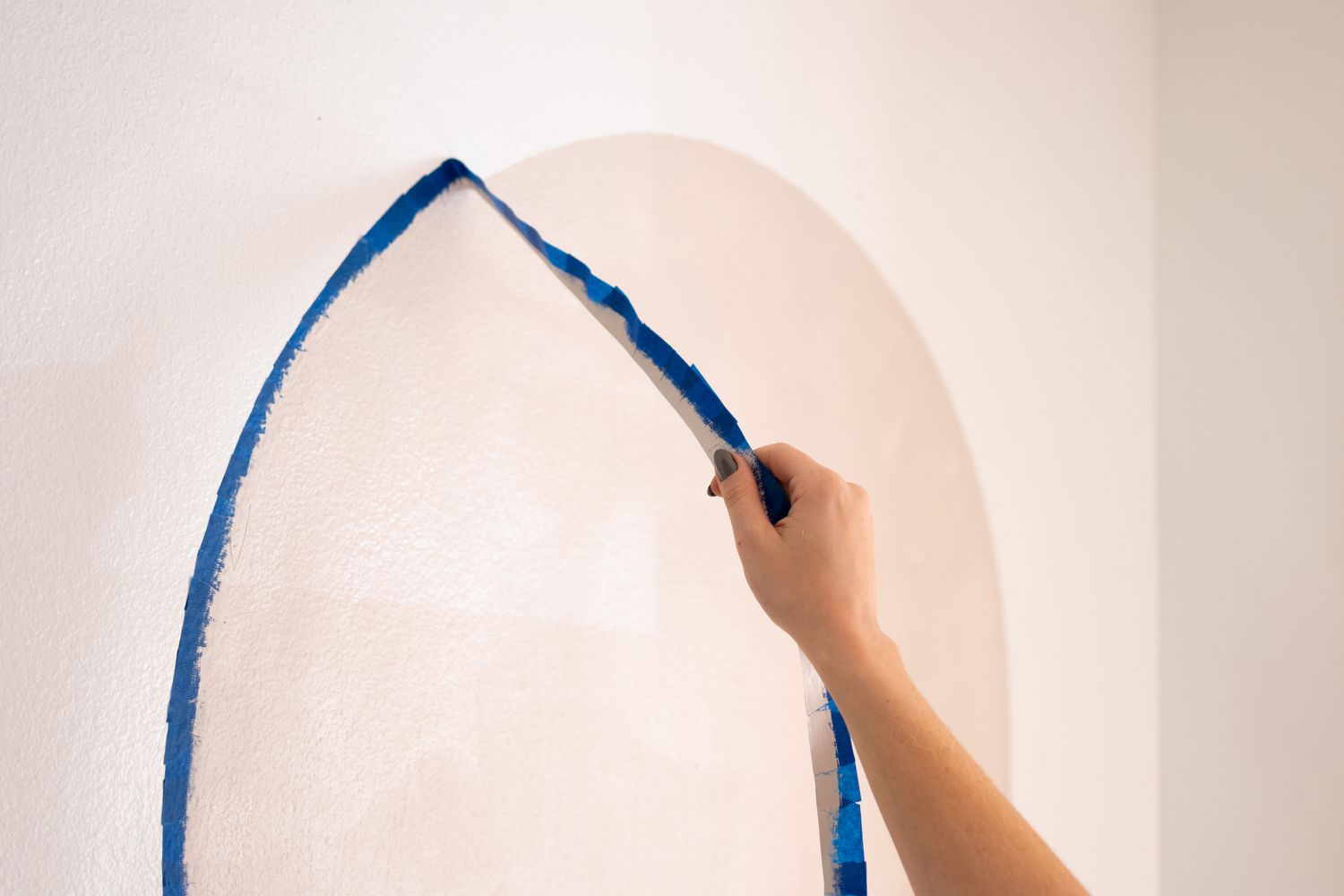 Fita de pintor removida da parede para expor o arco pintado DIY