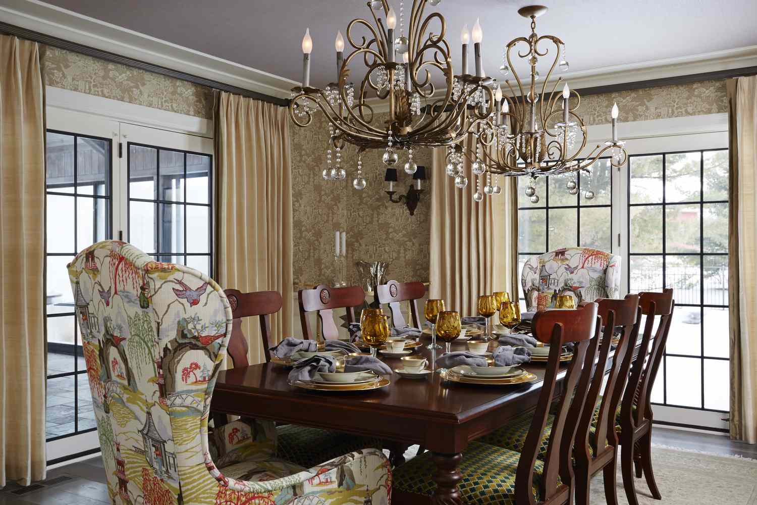 Formal vintage dining room with ornate chandelier and wallpapered walls.
