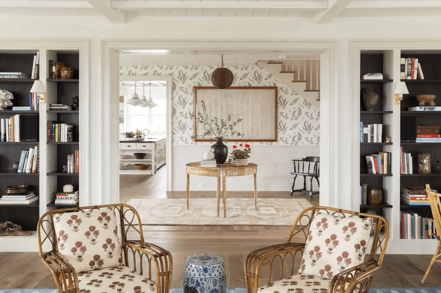 Ein Wohnzimmer im Küstenlandhausstil, gefüllt mit Korbwaren, rustikalem Holz und Blumenmöbeln