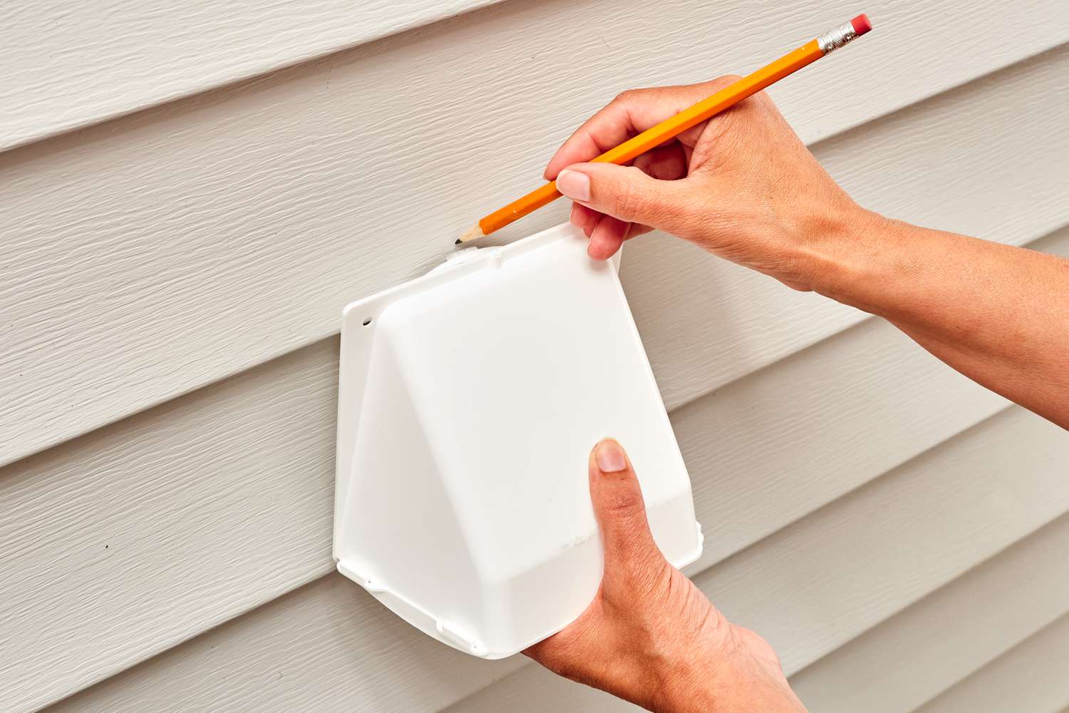 Vent cap placed on house exterior and marked with pencil