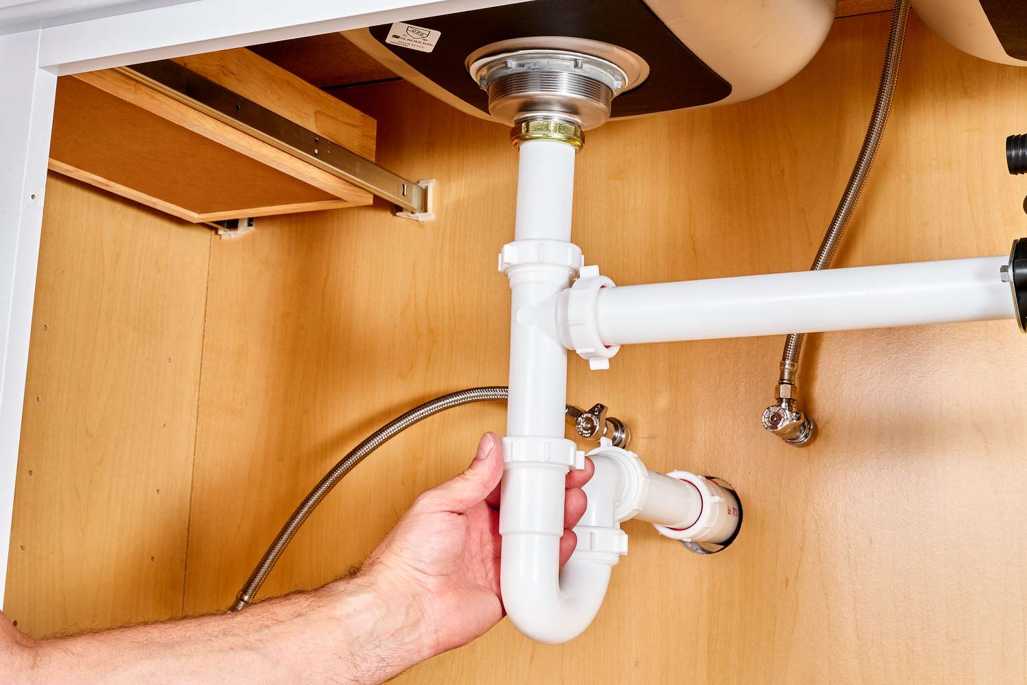 Drain trap connected to trap arm under sink