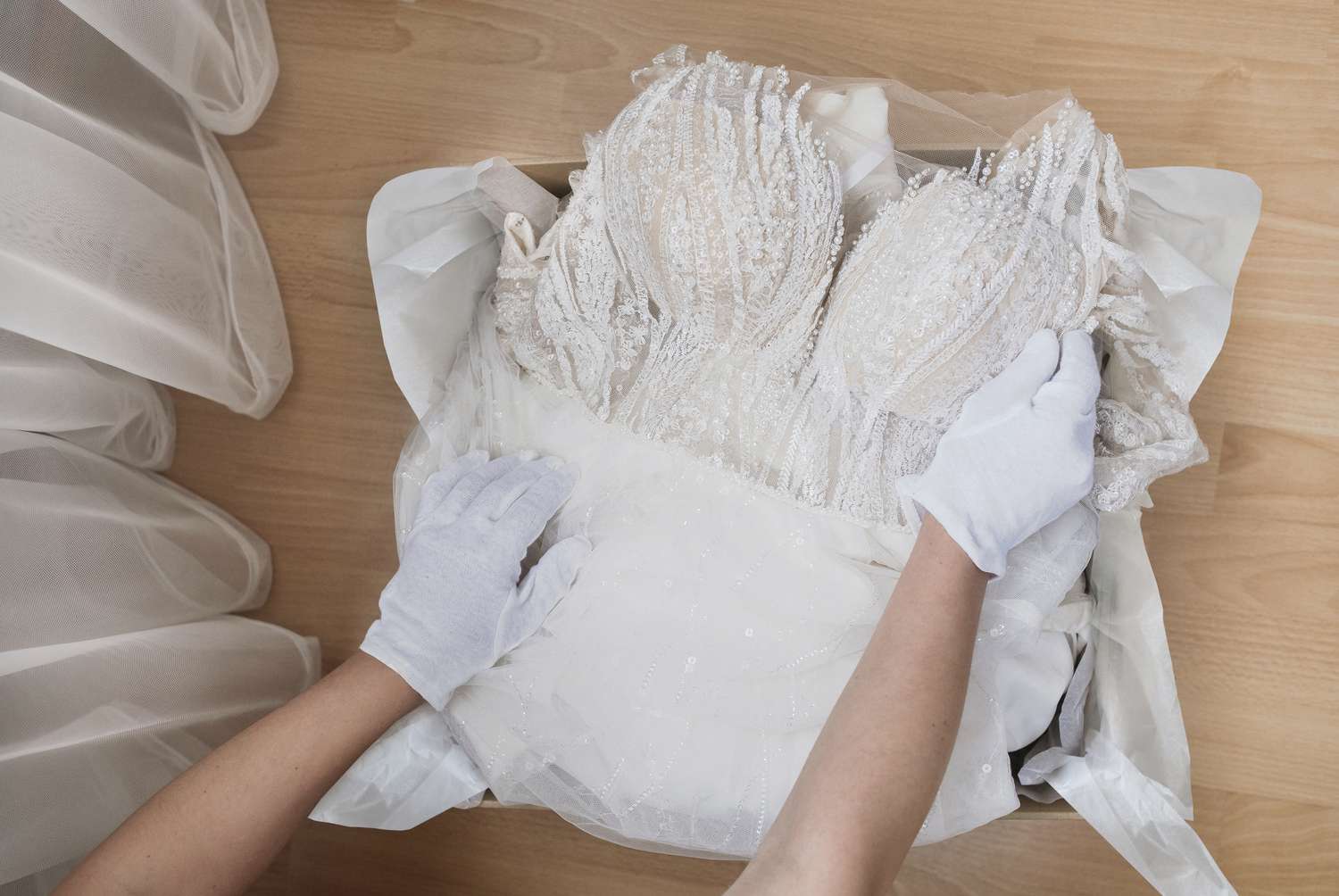 Hochzeitskleid wird in einer Schachtel mit weißen Handschuhen aufbewahrt