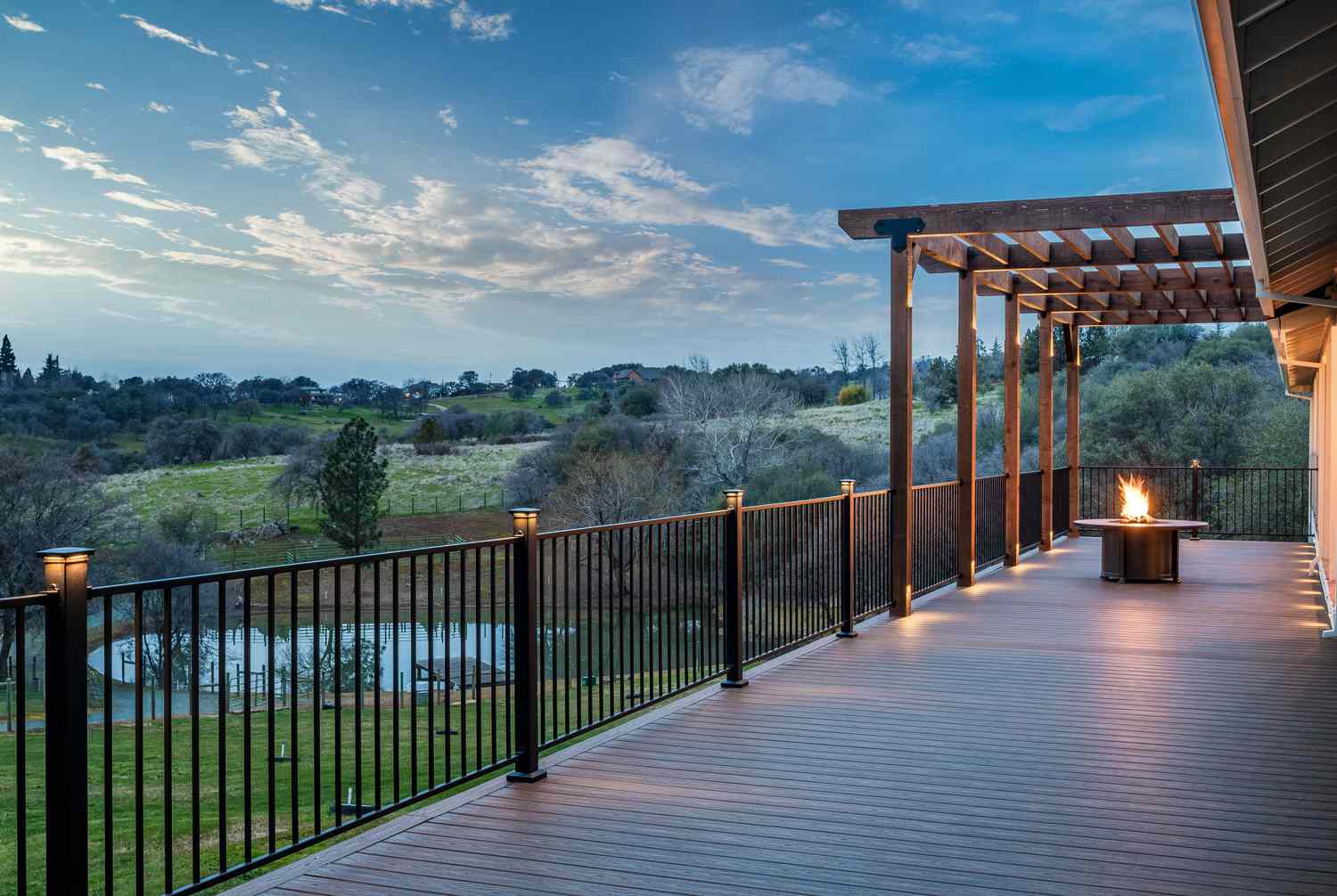 Um deck com vista para um campo e um lago