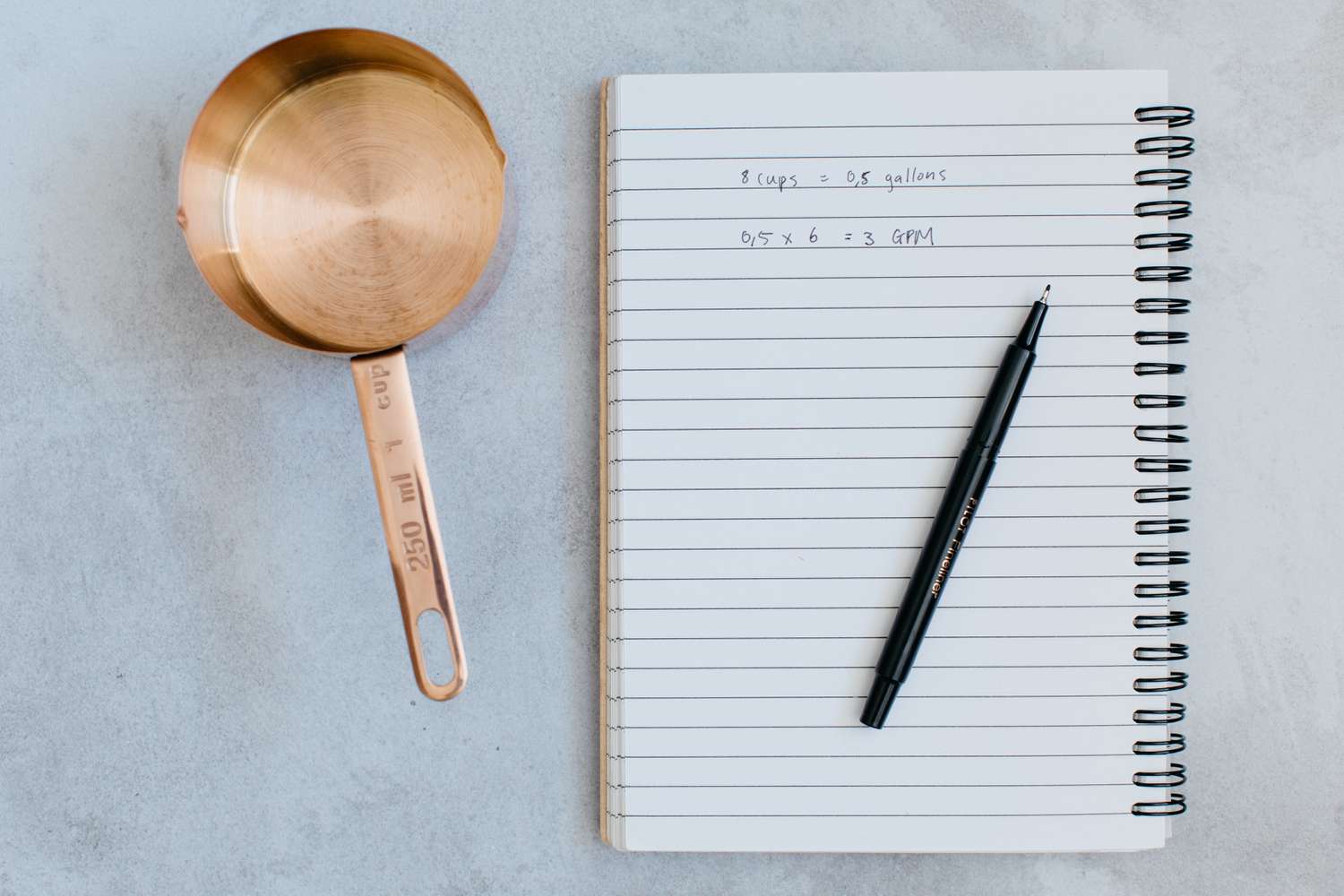 Bloc-notes avec quantités d'eau mesurées écrites au stylo