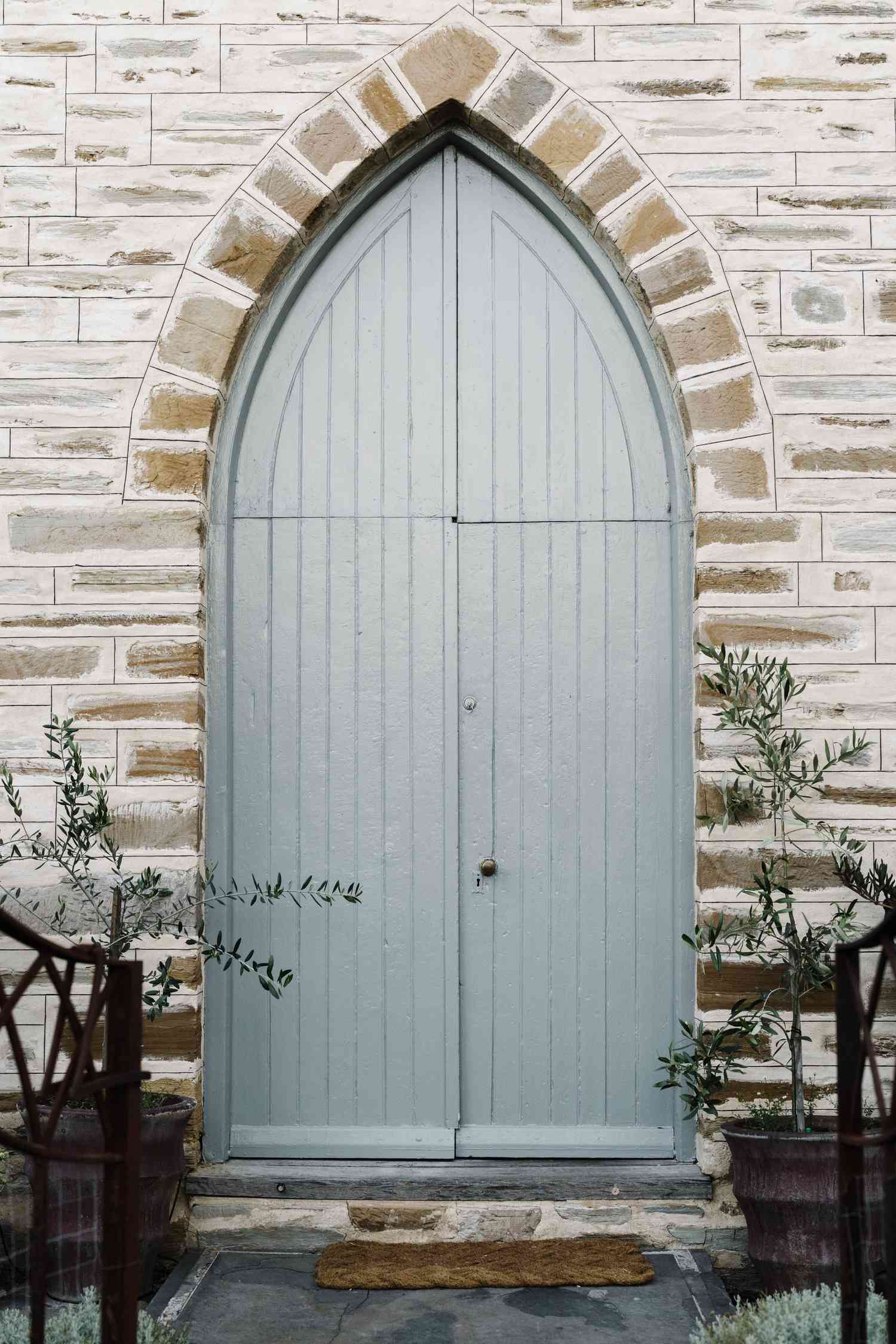Puerta azul de iglesia con plantas cerca