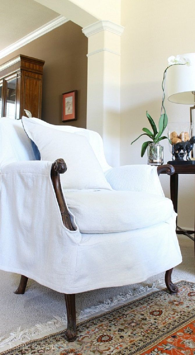 Un sillón blanco forrado de tela.
