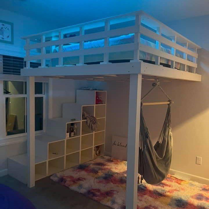 Una cama alta para niños con cubos de almacenaje y una hamaca en la parte inferior.