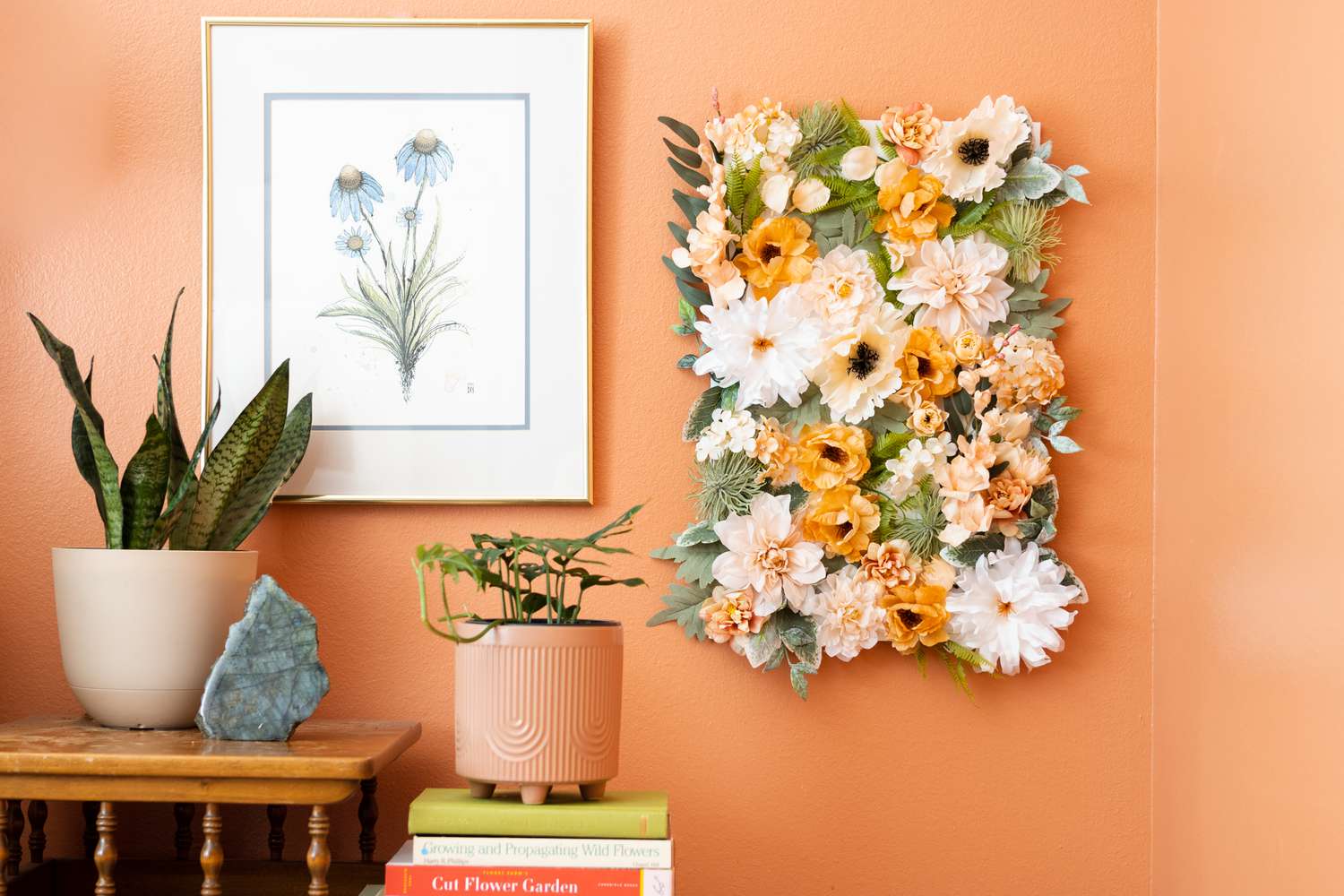 DIY pared de flores colgando en la pared de color naranja junto a la impresión de flores colgantes y plantas de interior