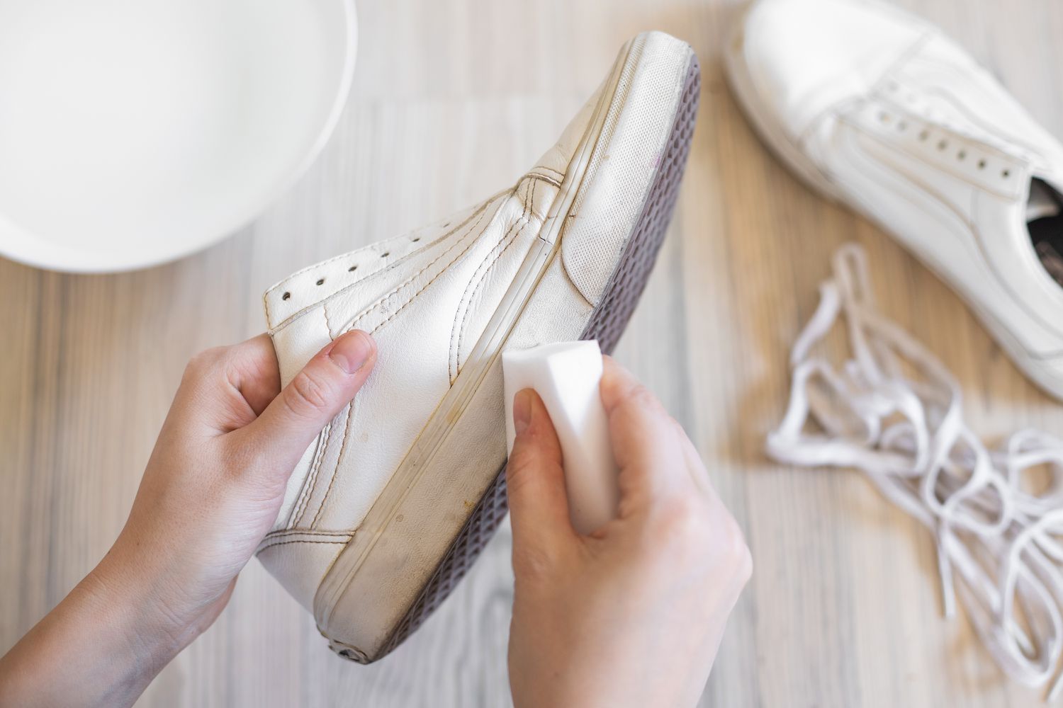 White leather van shoes being cleaned with melamine sponge