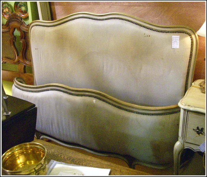 An antique French upholstered bed