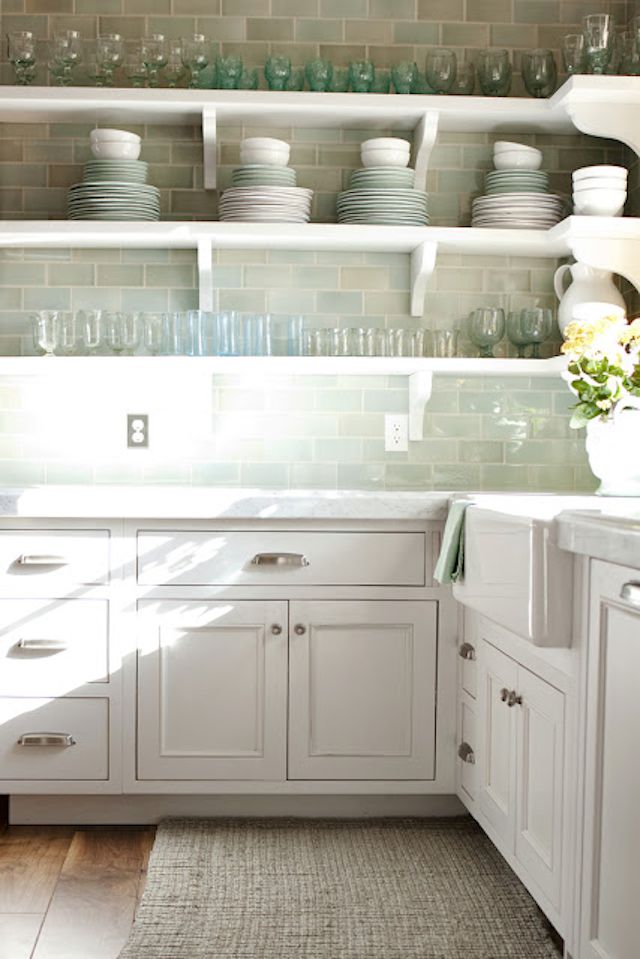 a kitchen with sea green backsplash