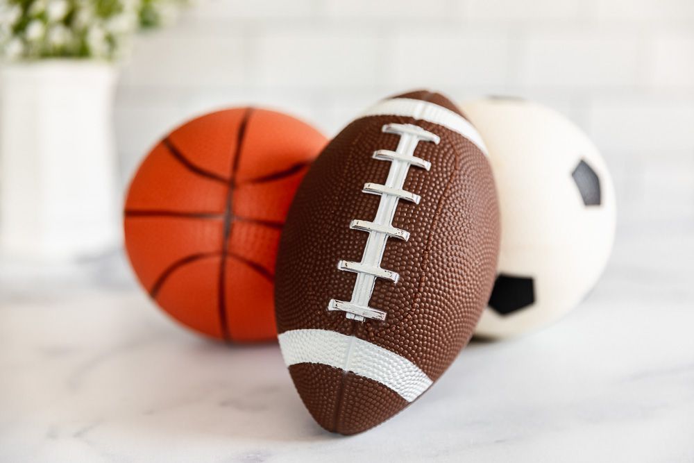 Kleiner Fußball, Basketball und Soccerball auf weißer Fläche gegen Bargeld zu verkaufen