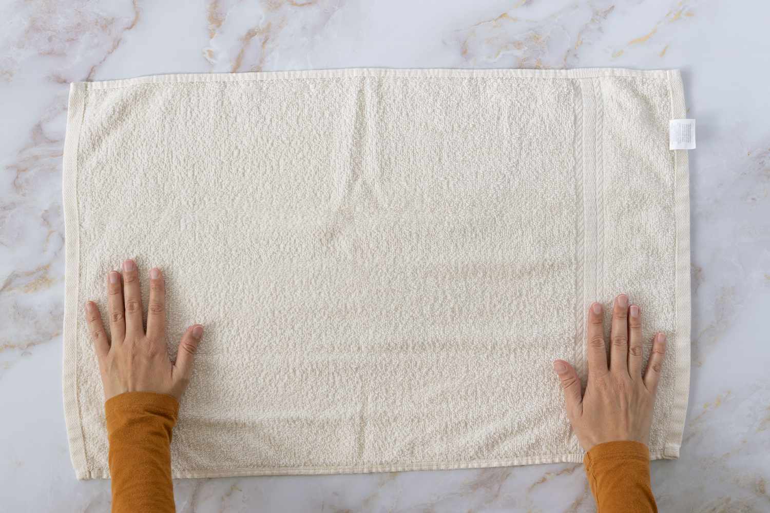 Large cream towel laid flat on marbles surface 