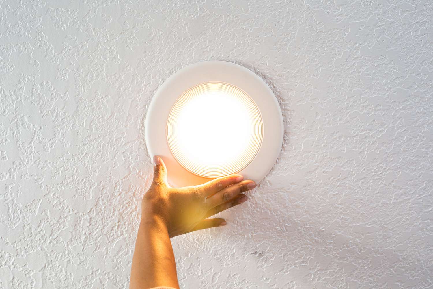 Einbauleuchte in der Hand mit eingeschaltetem Licht