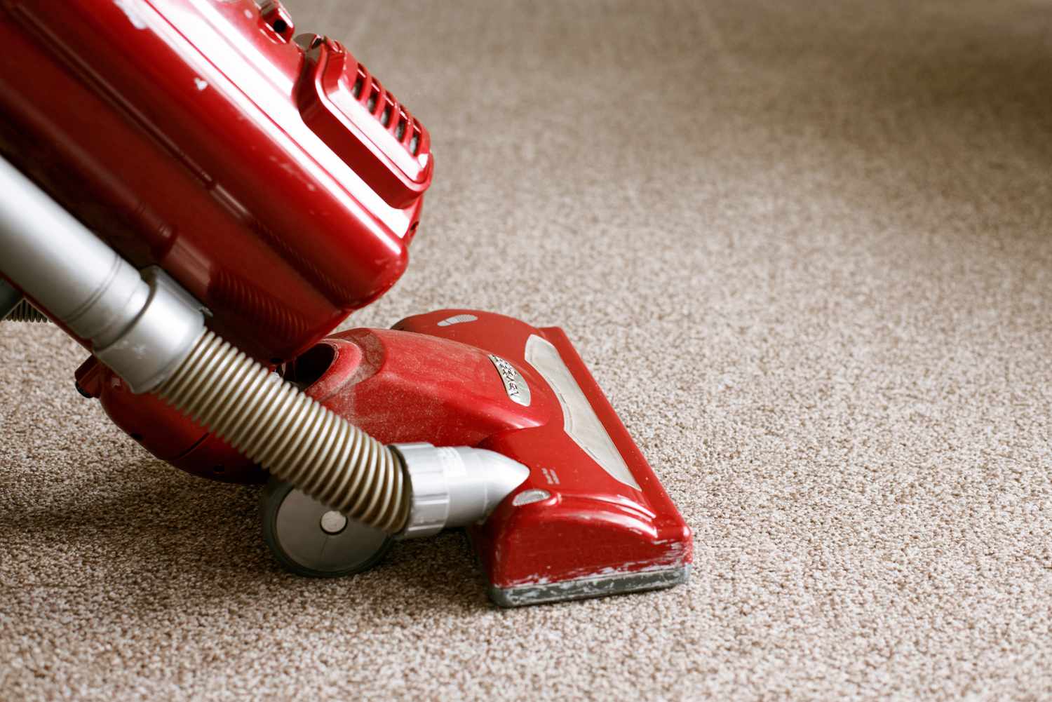 Red vacuum cleaning tan carpet