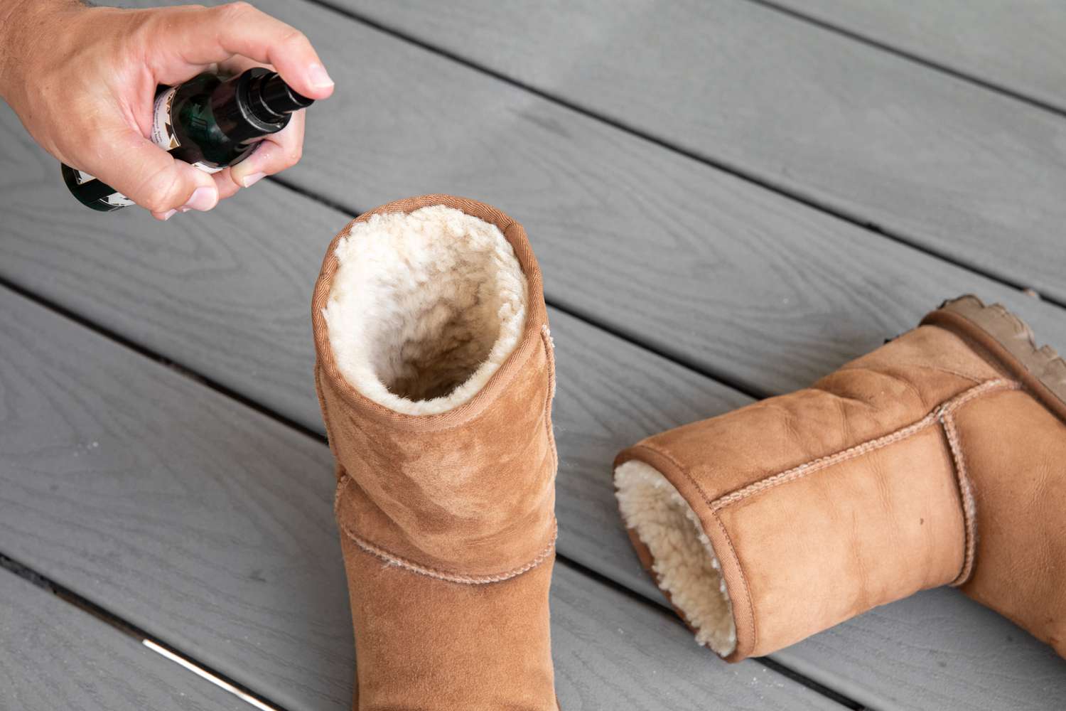 Someone using fungal spray inside an Ugg boot
