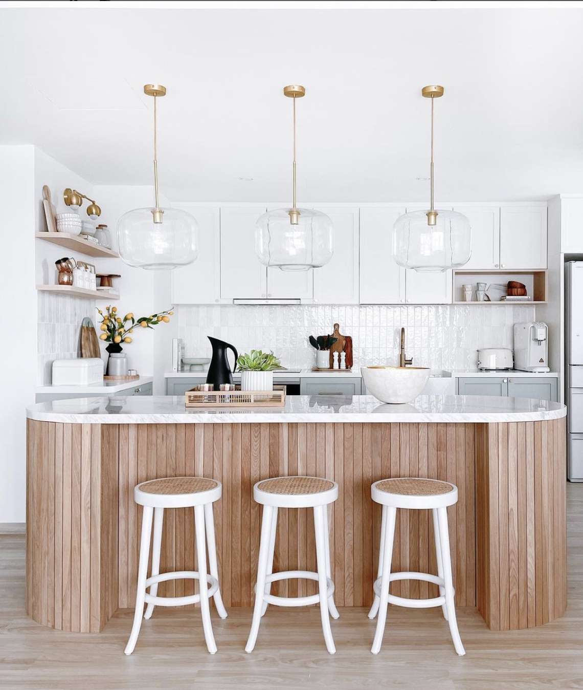 cocina blanca moderna con isla de paneles de madera