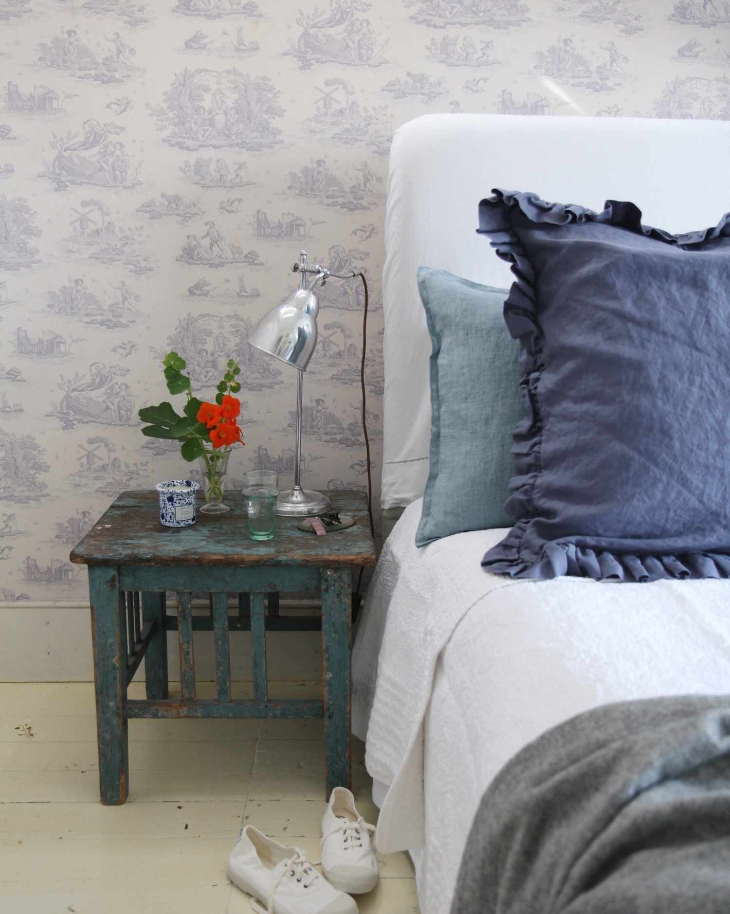 Cottage bedroom with rustic side table.