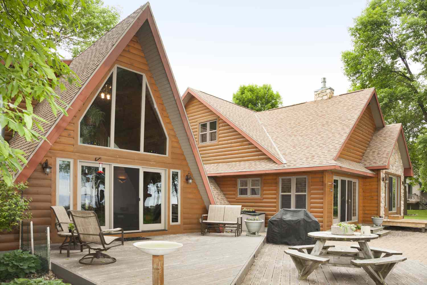 A-Frame log cabin with outdoor seating on wooden deck