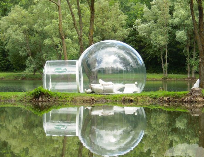 Espaço de vida portátil de bolhas de plástico transparente em uma margem de lago