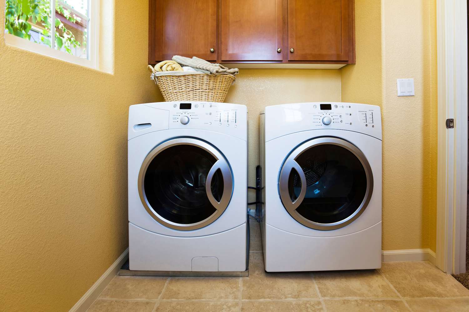 Lavadora e secadora modernas brancas na lavanderia da casa.