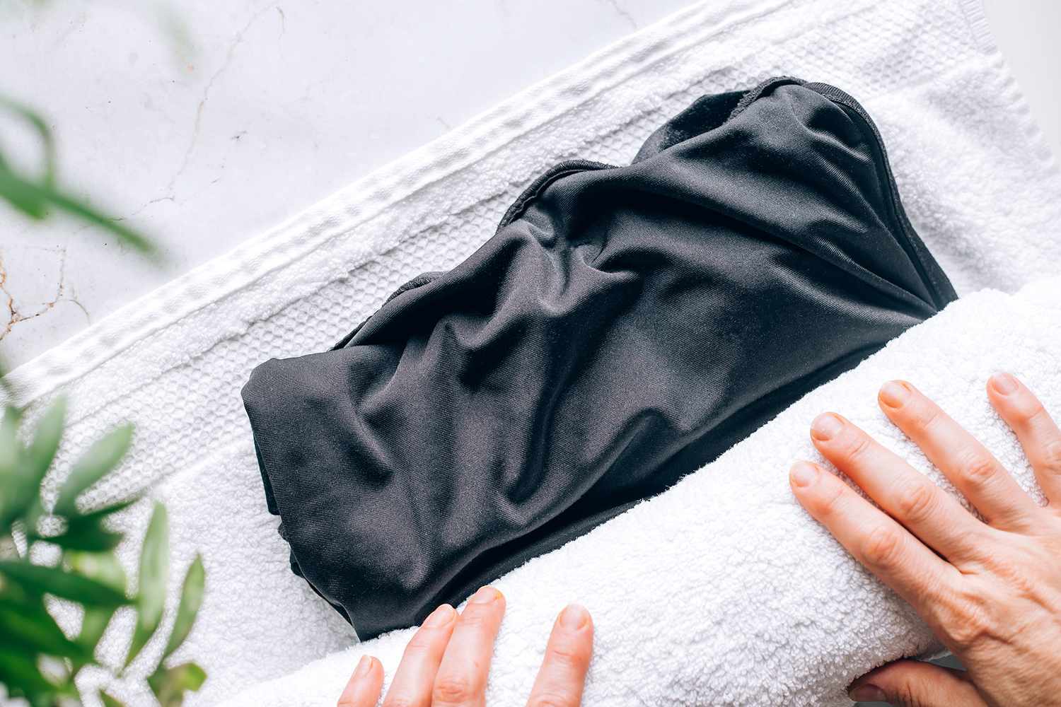 Tela de seda negra enrollada en toalla blanca para secar