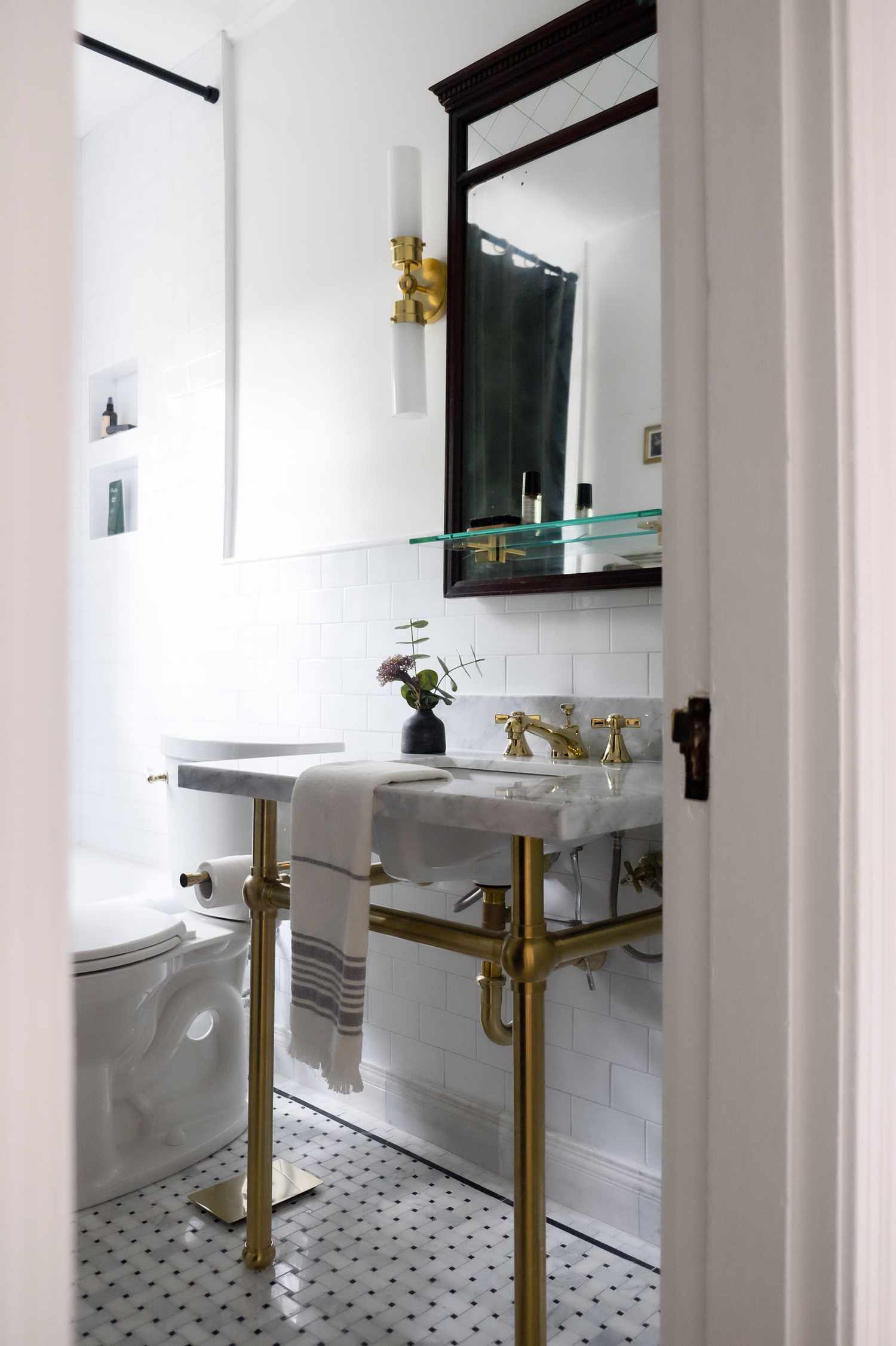 Salle de bain contemporaine blanche avec des accents or et noir