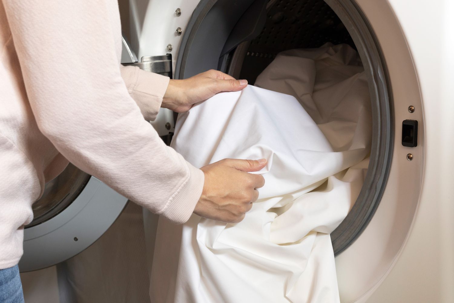 Roupa de cama coberta de ácaros colocada na máquina de lavar