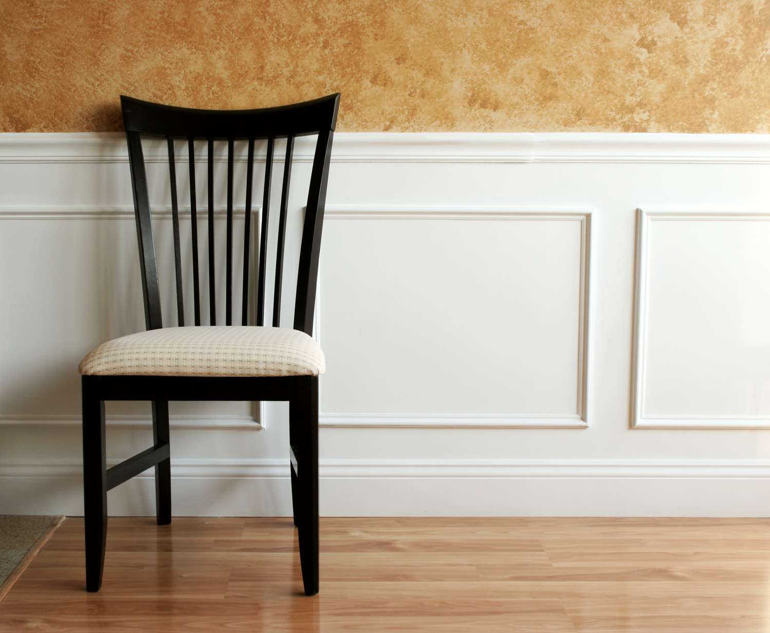 Painel de lambril branco com cadeira de jantar contra ele