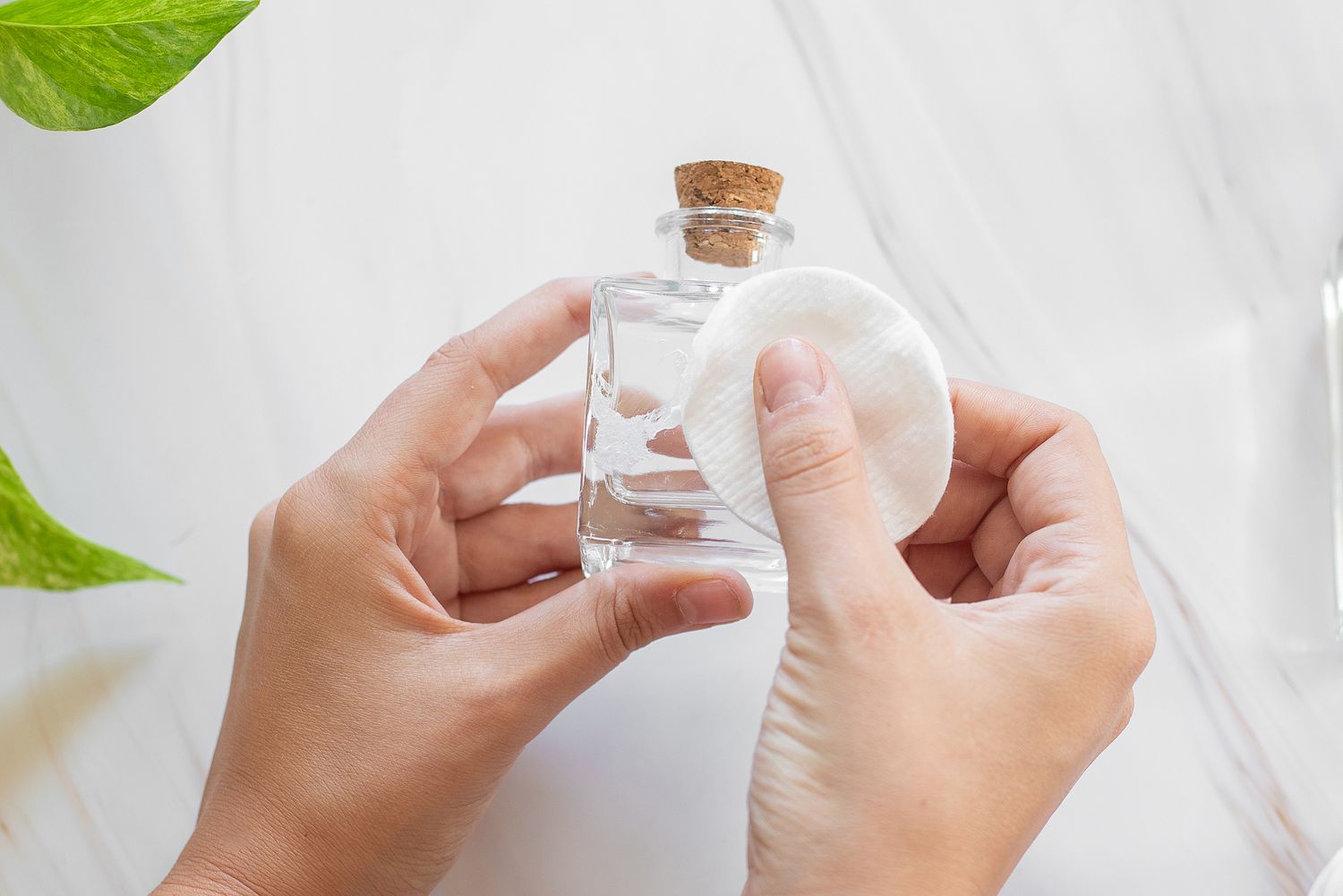 Reinigungsalkohol, der mit einem Wattebausch in ein Glasgefäß gegeben wird, um Klebebandreste zu entfernen