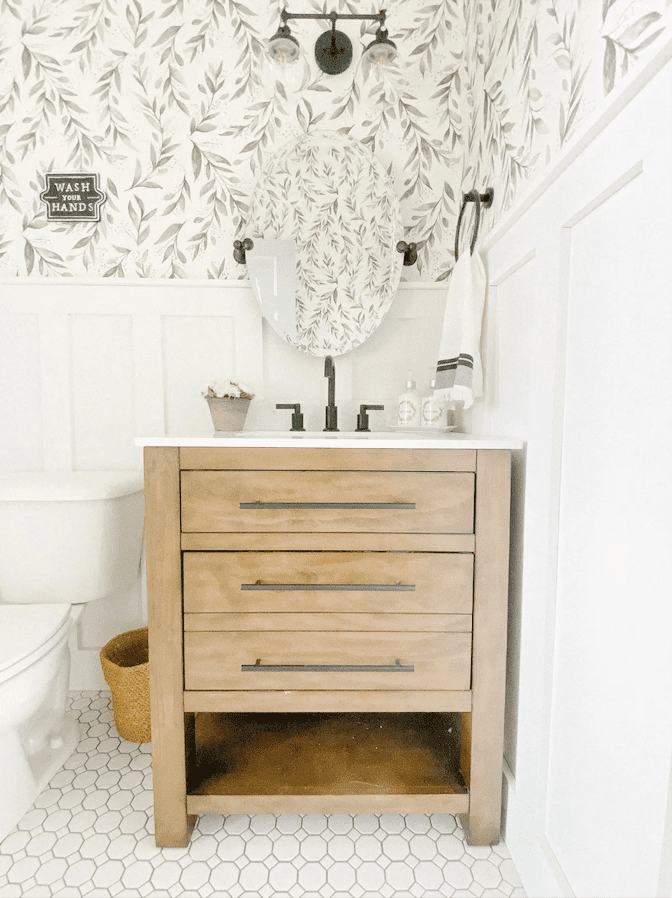 Baño con tocador de madera y papel pintado floral