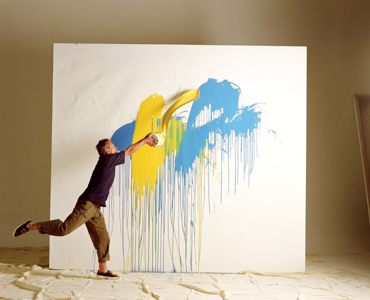 Künstler wirft Farbe auf Leinwand