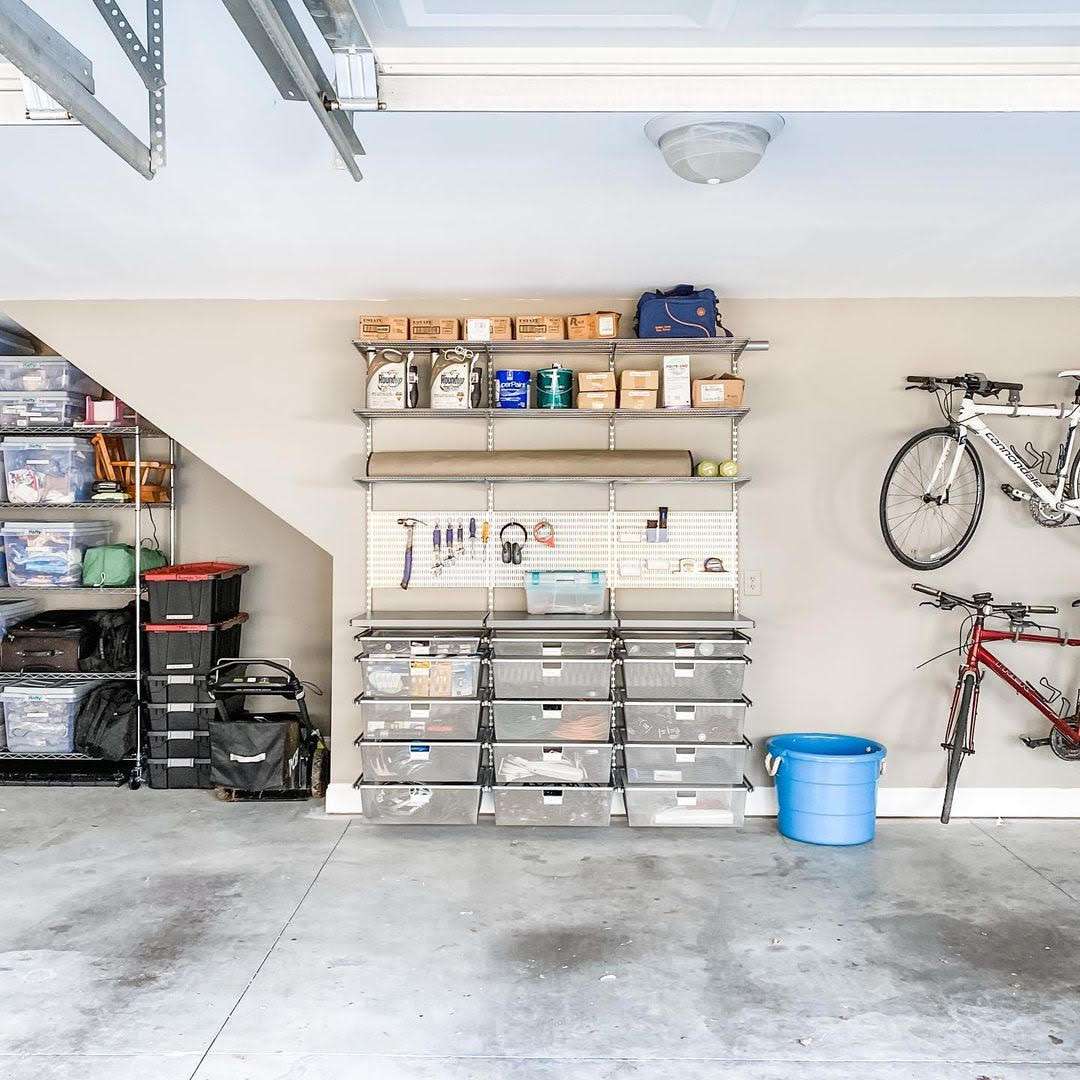 Garage avec étagères, système de rangement à tiroirs et vélos au mur