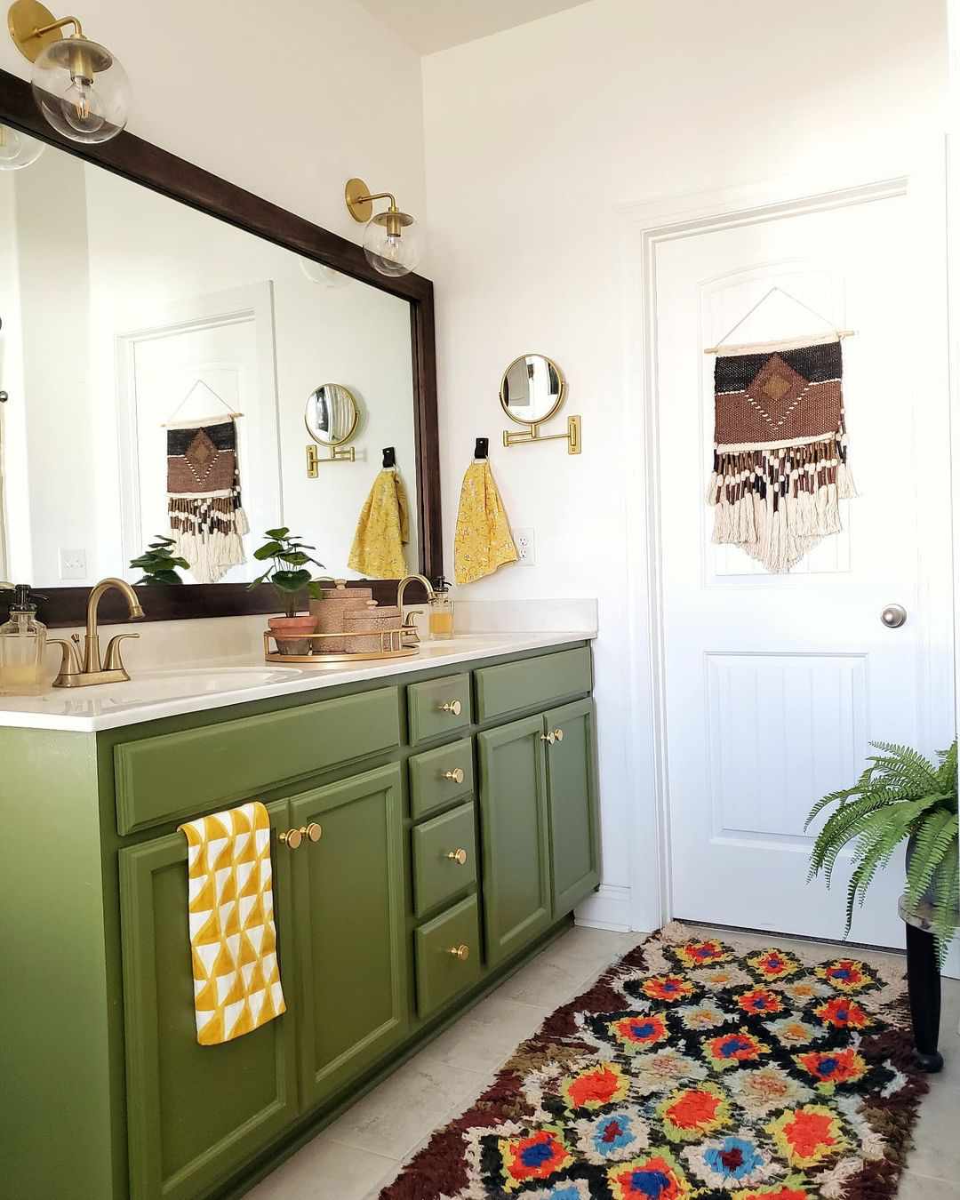 Ein Badezimmer mit grünem Waschtisch und bunten Accessoires