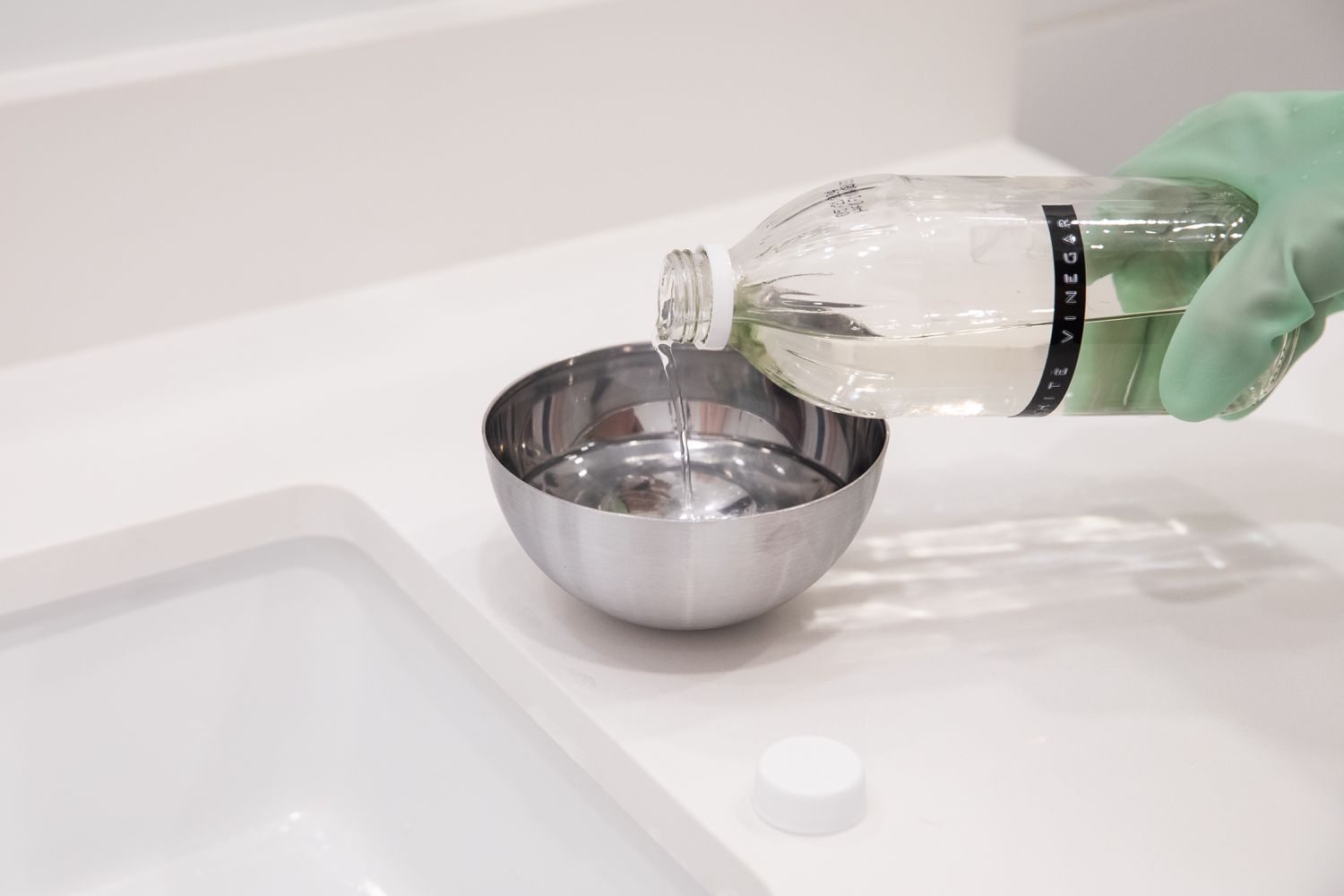 Vinagre blanco destilado vertido en un cuenco metálico con agua como solución limpiadora