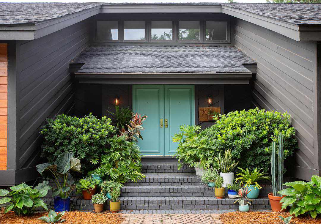 Ein kohlegraues Haus mit einer ozeanblauen Eingangstür