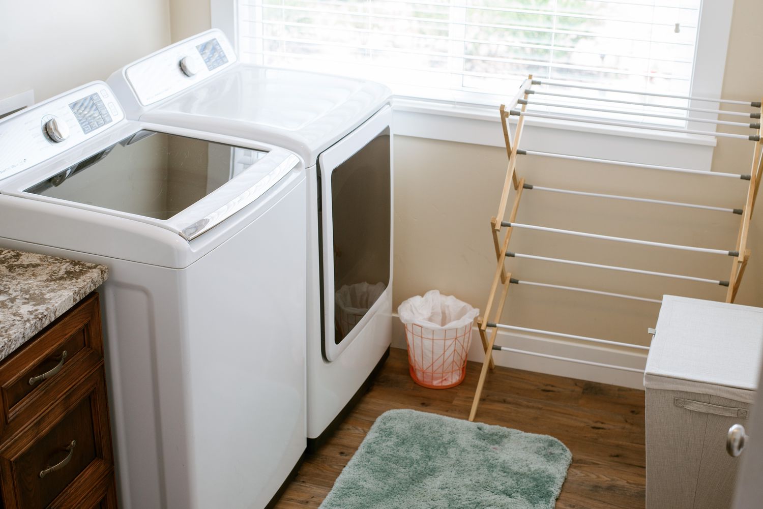 Waschküche mit Wäscheständer und weißen Maschinen am hell erleuchteten Fenster