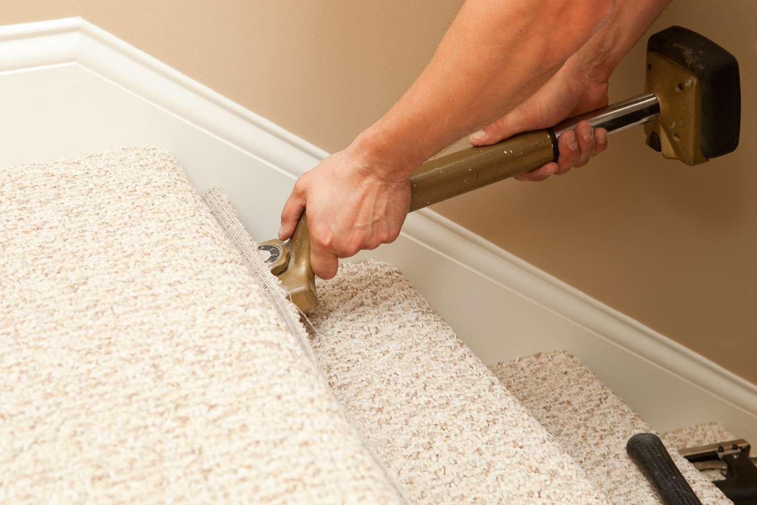 Installateur verlegt Teppich auf einer Treppe