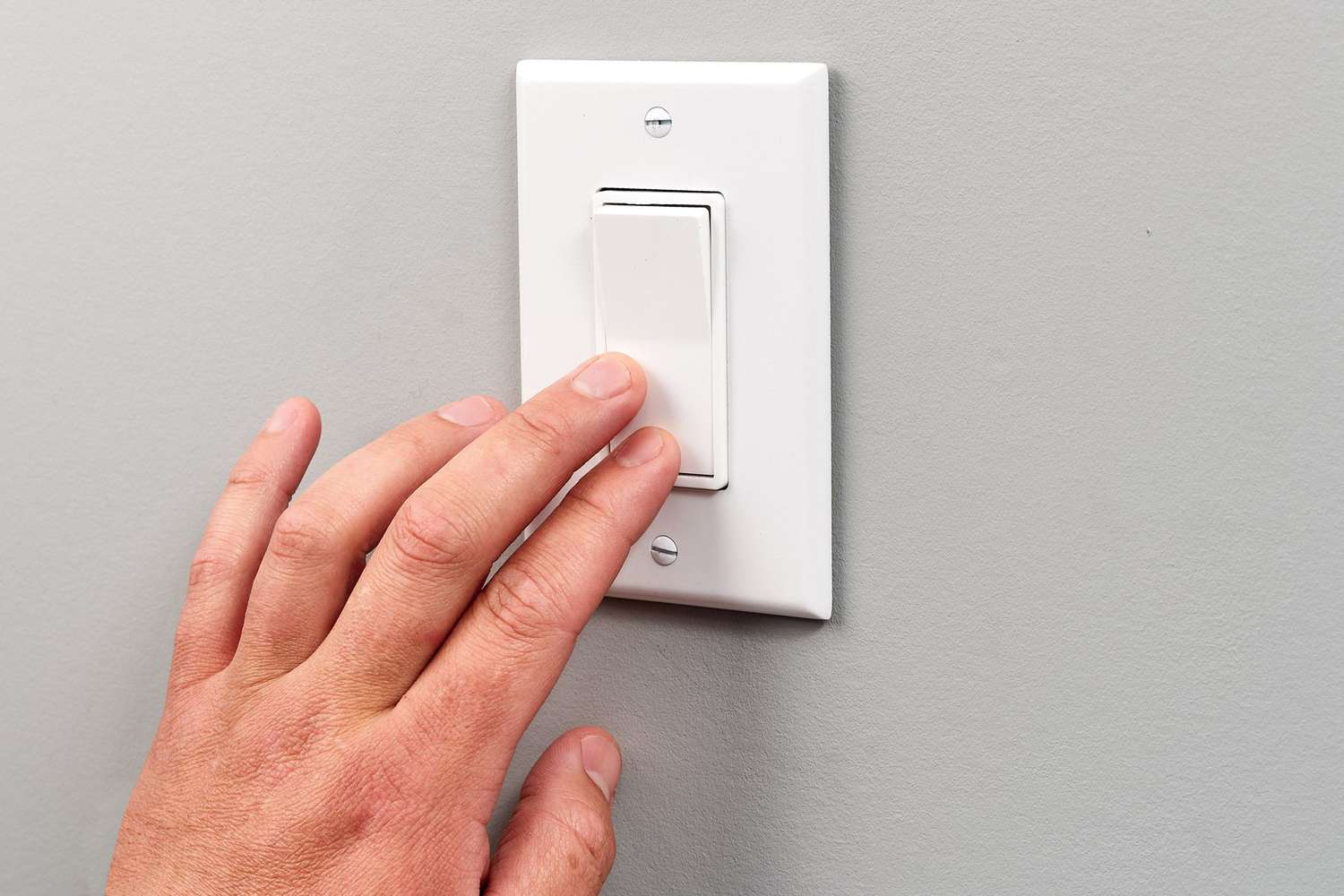 Warm light switch touched by hand 