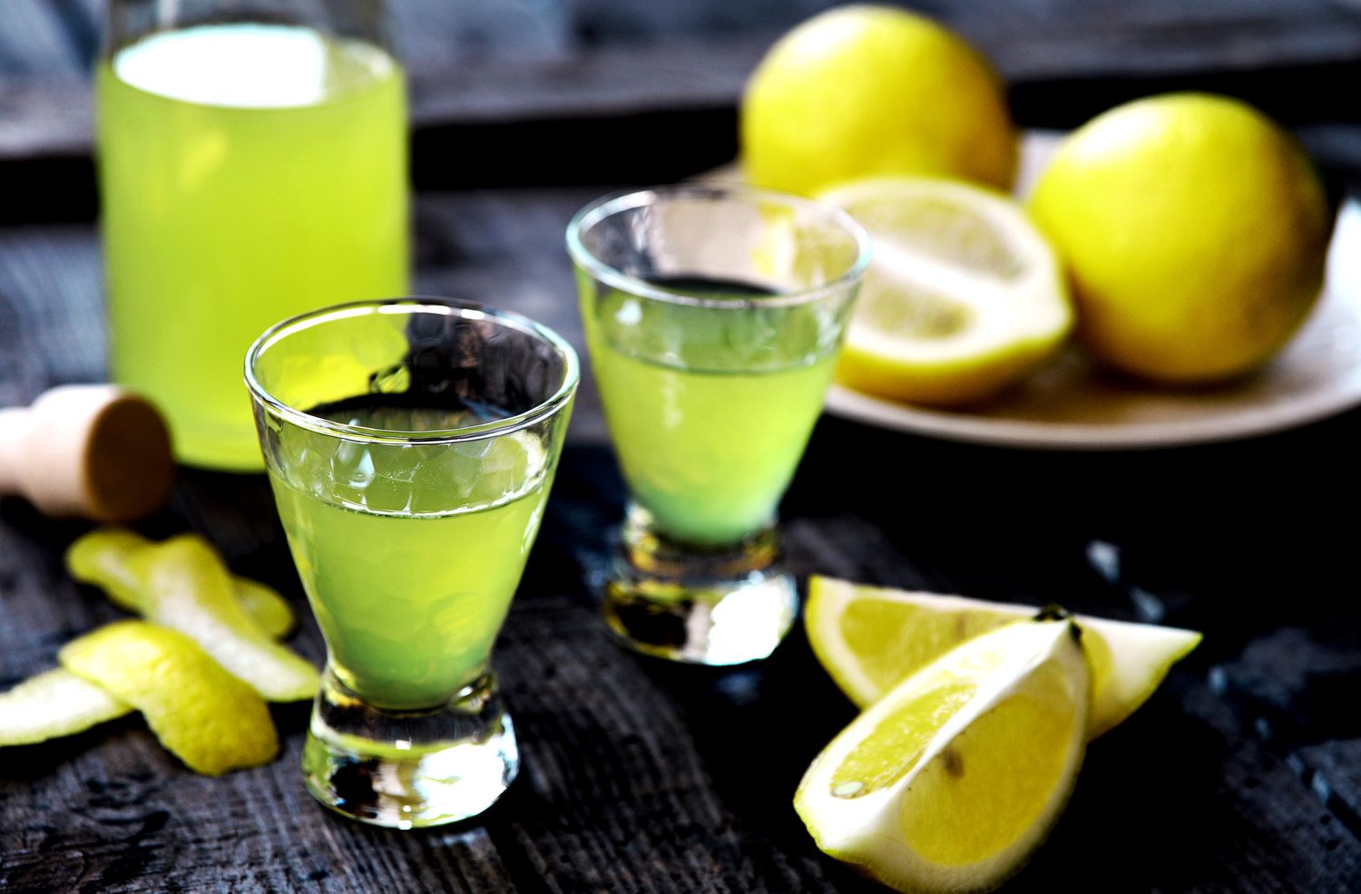 Shots of Limoncello with lemon wedges.
